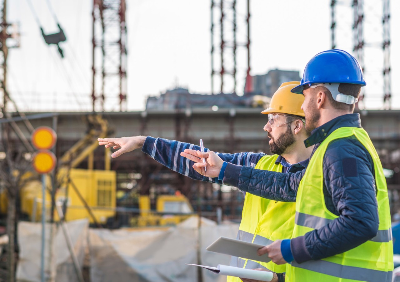 Construction workers pointing into the distance. 