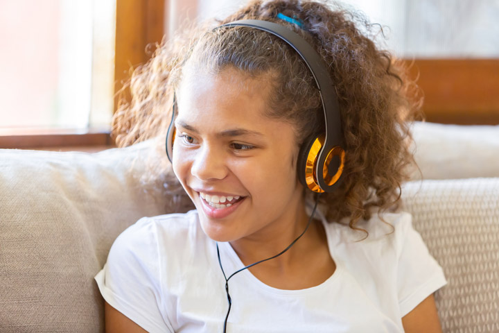 Young Aboriginal girl listening to music on headphones