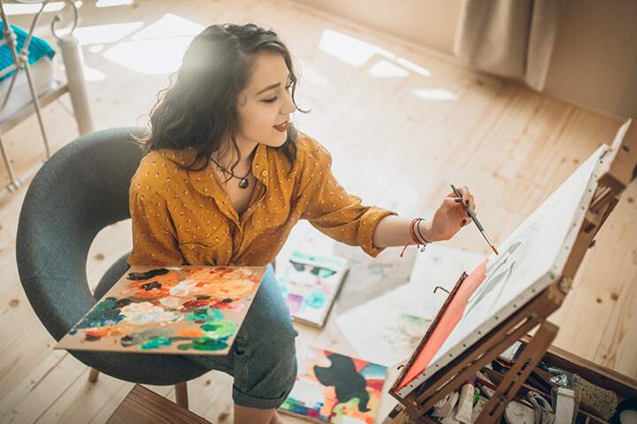 Female painter creating artwork on a canvas in her studio