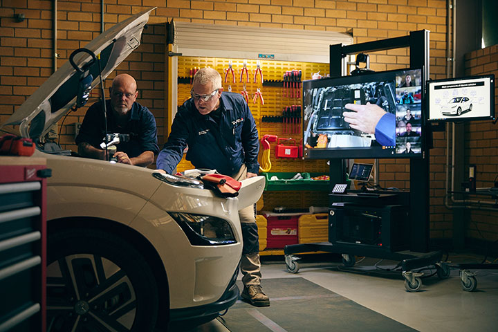 Electric car mechanic student and teacher