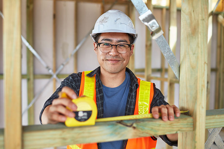 Man in building site with tape measure