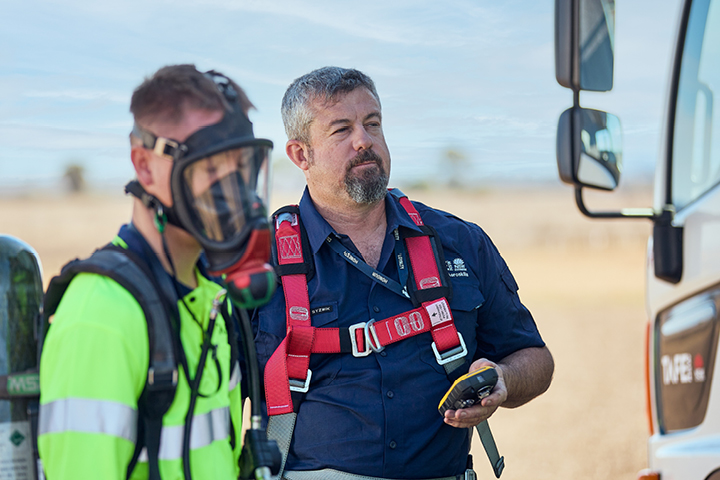 A student and teacher wearing safety equipment.