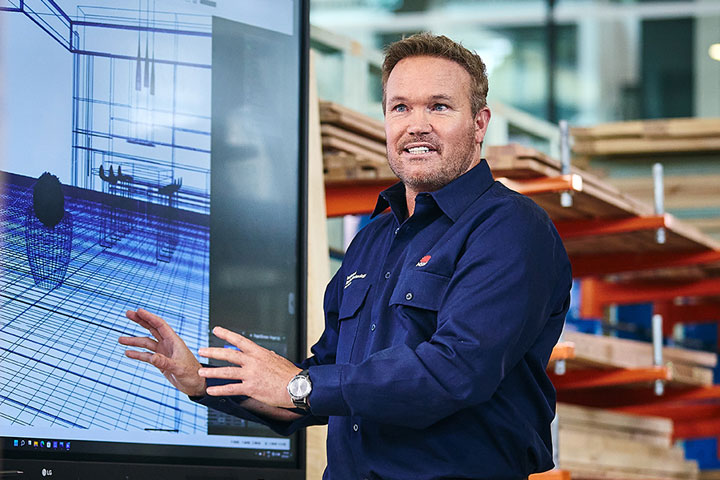 Construction teacher reviewing design plans with students