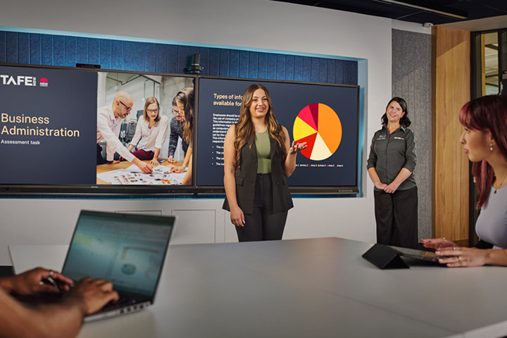Female student presenting to her peers in a classroom