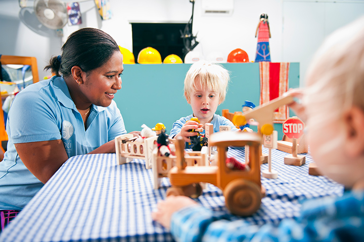 Woman enjoying playful moments with children and wooden toys