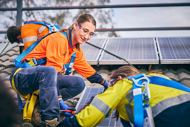 Renewable energy student installing solar panels.