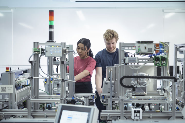 two students in front of machinery
