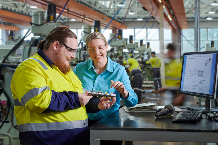 Student and teacher in a working factory