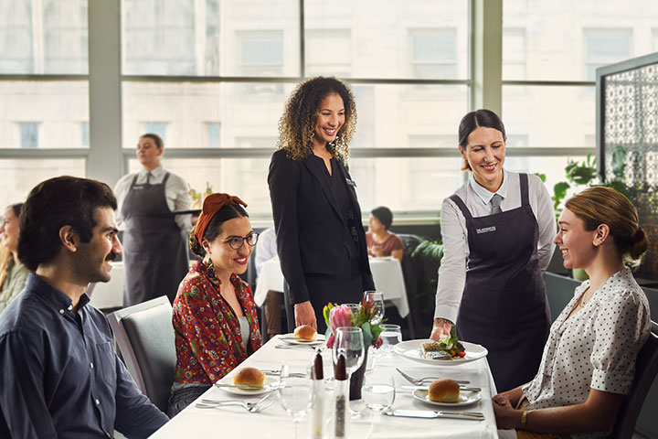 Teacher and student waiting on diners