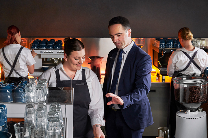 Manager providing guidance to staff in coffee shop