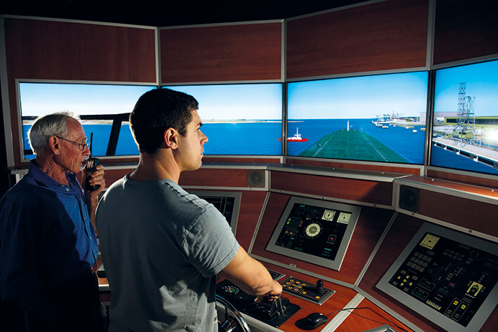 Maritime teacher and student working on a simulator.