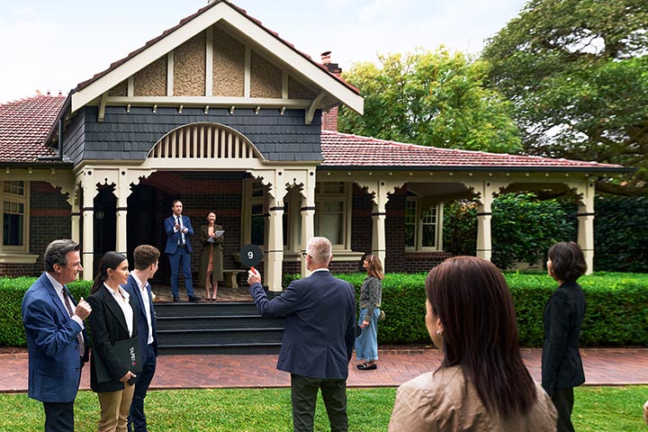 Traditional Australian home with hedge-lined porch, currently under auction.