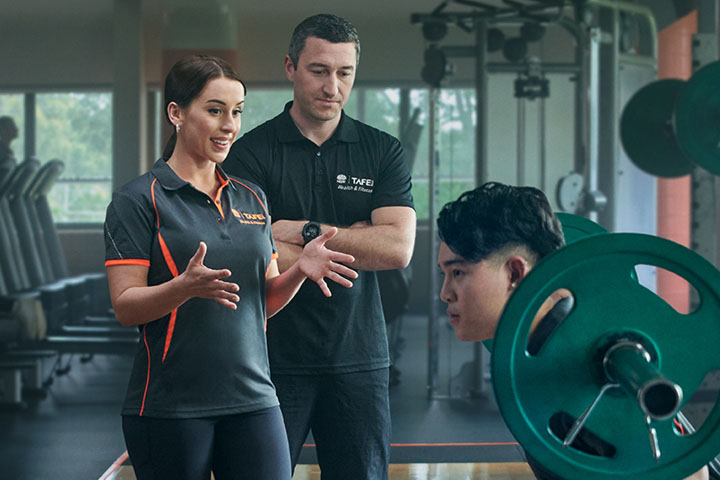 Teacher assisting a student in training to become a personal trainer.