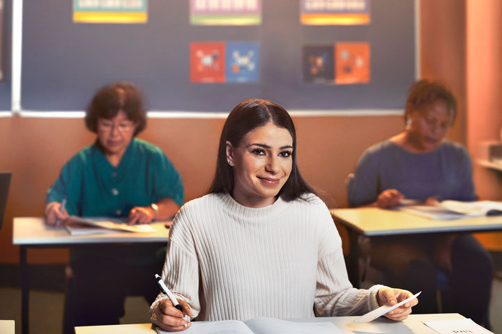 Student immersed in a diverse classroom environment, surrounded by peers, fostering a supportive atmosphere for language learning and communication skills development.