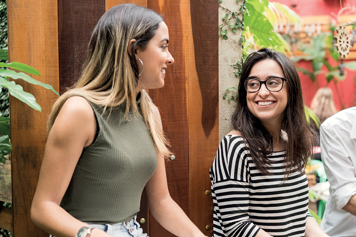 Two young women sitting outdoors and chatting