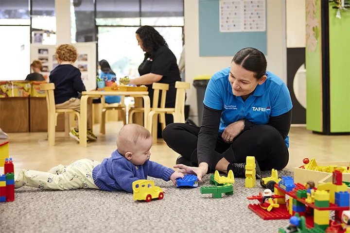 An early childhood education student engages in playful learning with a toddler.
