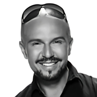 Black and white headshot of Alex Perry, smiling.