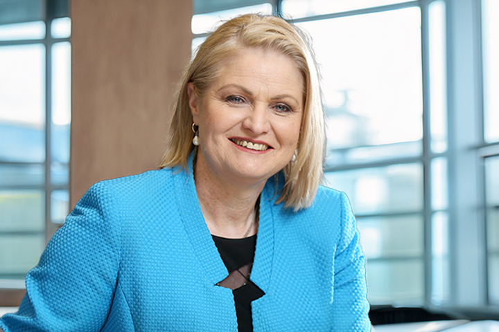 Katrina Troughton is smiling at the camera. She is wearing a bright blue jacket.