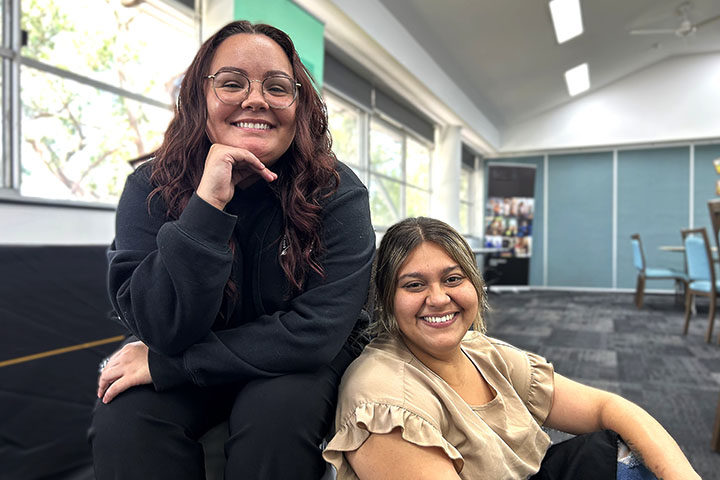 Saraya Ardler and Raeir Blakeney smiling, while sitting side-by-side in a classroom.