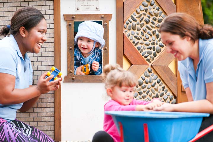 Early childhood educators working individually with kids outside.