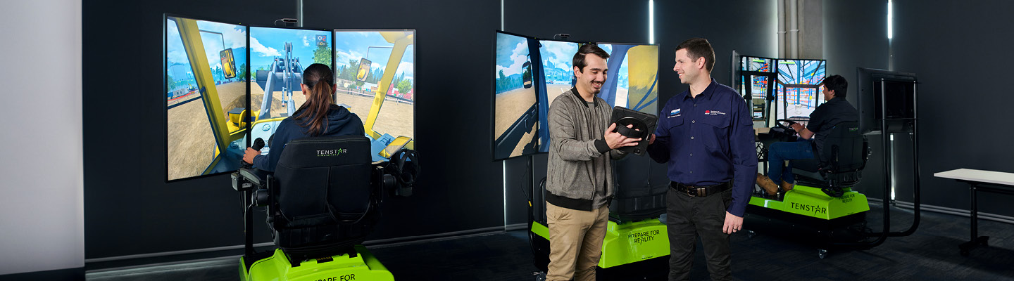 Civil construction students practicing on excavator simulators at the Institute of Applied Technology