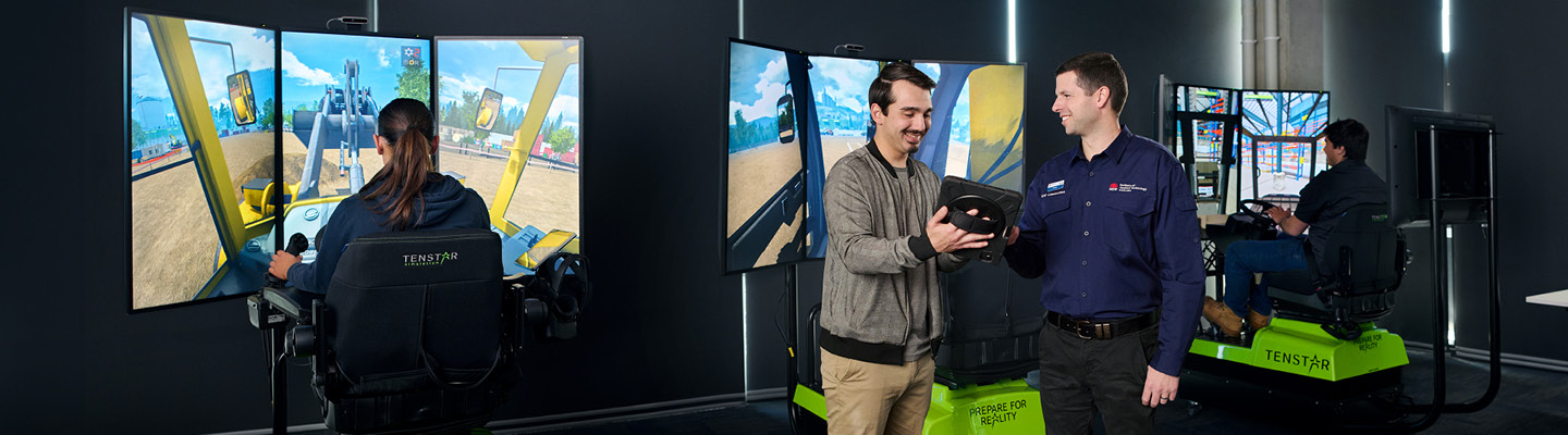 Civil construction students practicing on excavator simulators at the Institute of Applied Technology