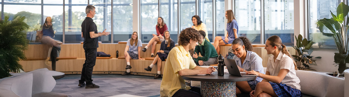 Students and teacher engaging in a casual brainstorming session in a bright, open environment