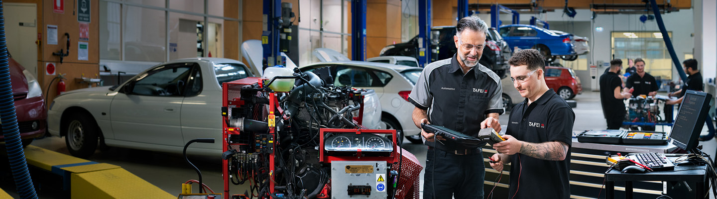Two people checking automobile conditions