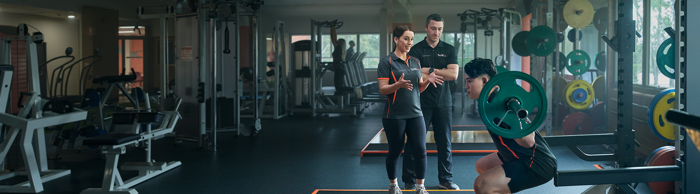 People giving a fitness instruction to a person lifting weights