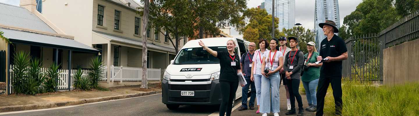 TAFE NSW staff and visitors gathered in front of a branded van during an event or visit.