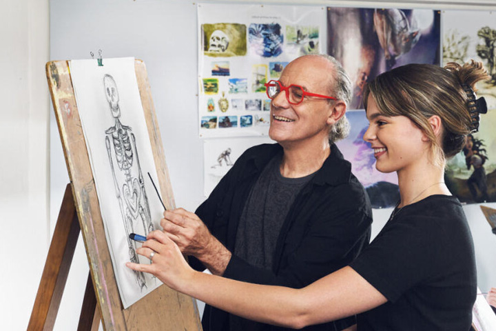 Two people working on a skeleton drawing