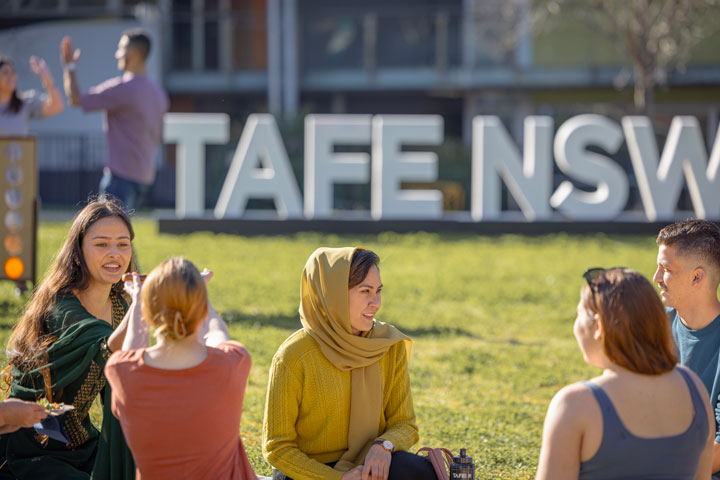 Students relaxing on grass at TAFE NSW campus