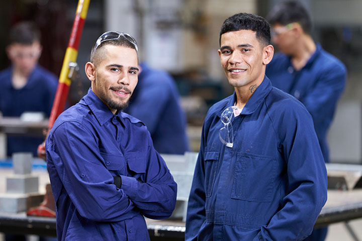 The Carr brothers posing for a photo in blue overalls