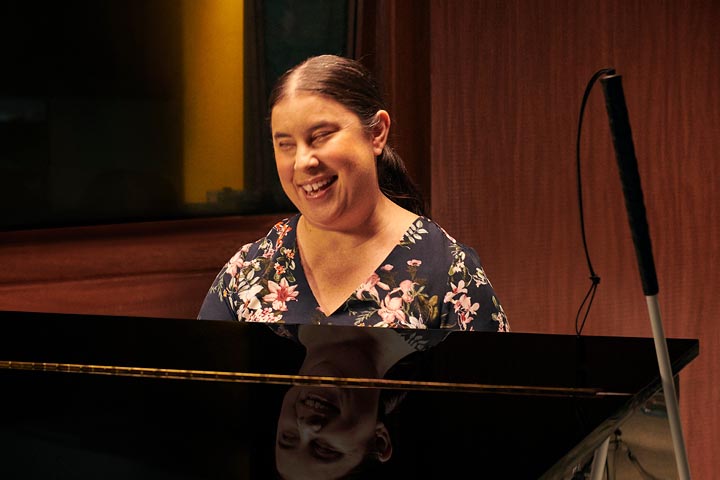 Young lady playing on a piano in a hall.