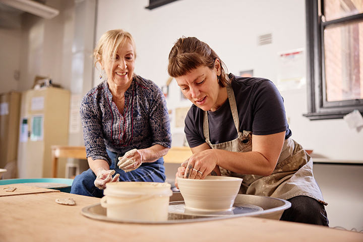 Creative ceramics session with students shaping clay in a workshop setting.
