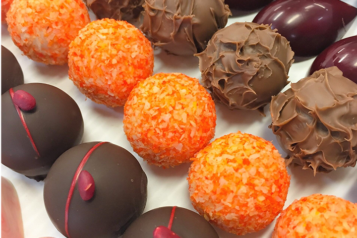 This image shows rows of assorted chocolates in different flavours and decorative elements.