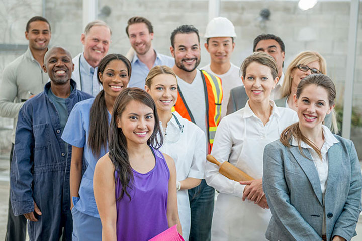 Diverse group of professionals including a construction worker, healthcare worker, and businessperson standing together, symbolizing collaboration across industries for sustainable practices and community development.