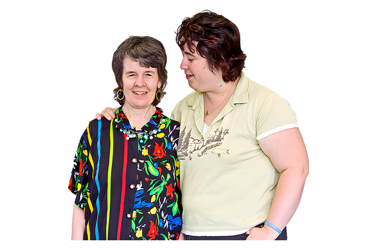 Two women standing closely together, smiling and showing support.