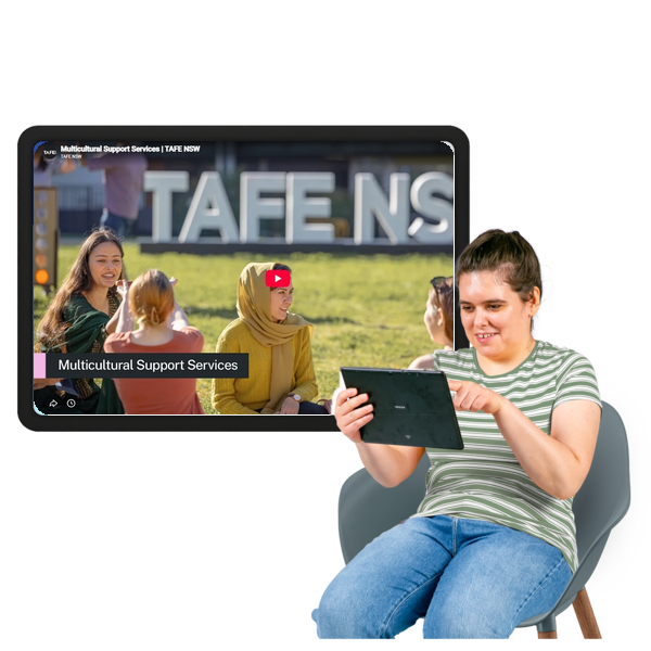 Woman using a tablet in front of a screen showing a multicultural support services video.