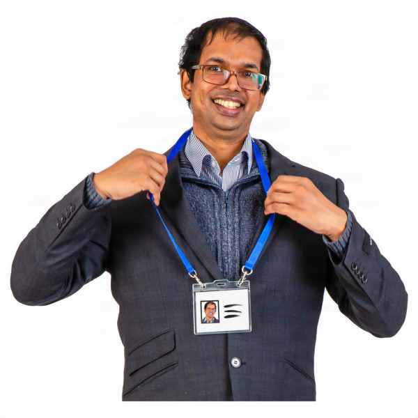 Smiling individual with glasses holding a blue lanyard with an ID badge.