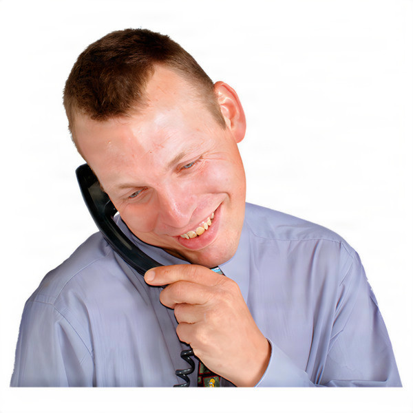 A man smiling while holding a phone to his ear. 