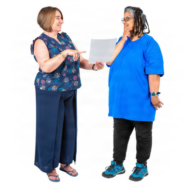 Two women talking, one holding a paper.