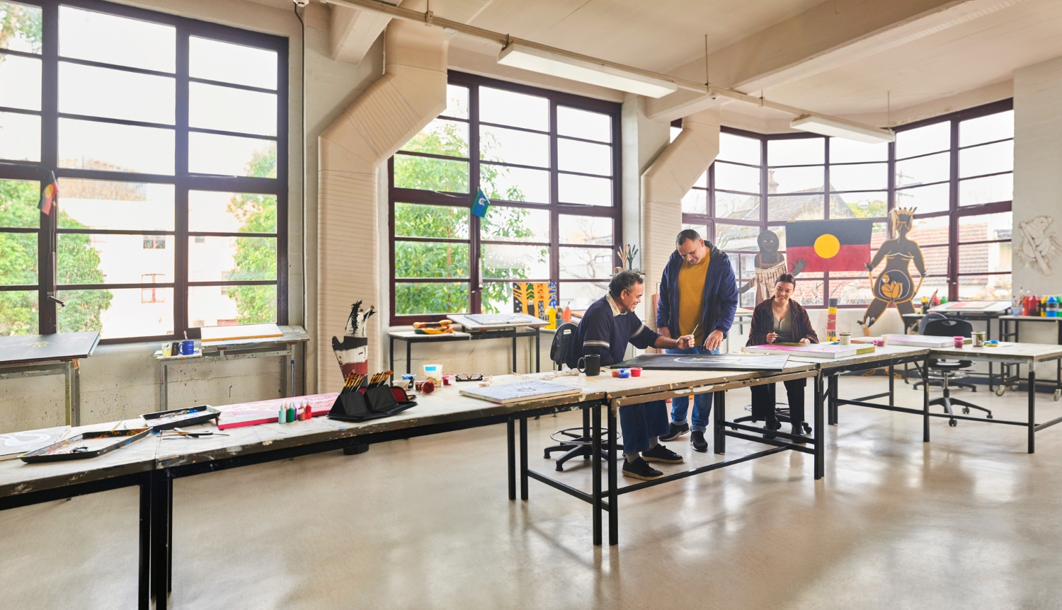 Three people working together in an Aboriginal study centre.