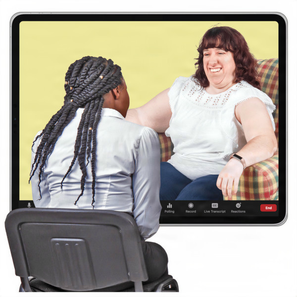 A woman with braided hair sits on a chair, facing a screen showing another woman smiling. 