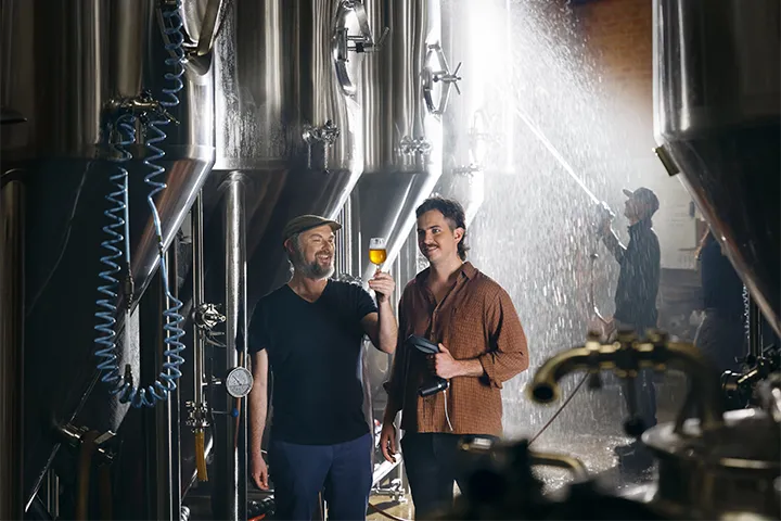 Student and teacher in a microbrewery, learning the craft of brewing