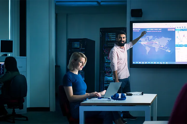 Teacher delivering a comprehensive presentation to a group of attentive students, fostering knowledge and skills in the realm of digital security.