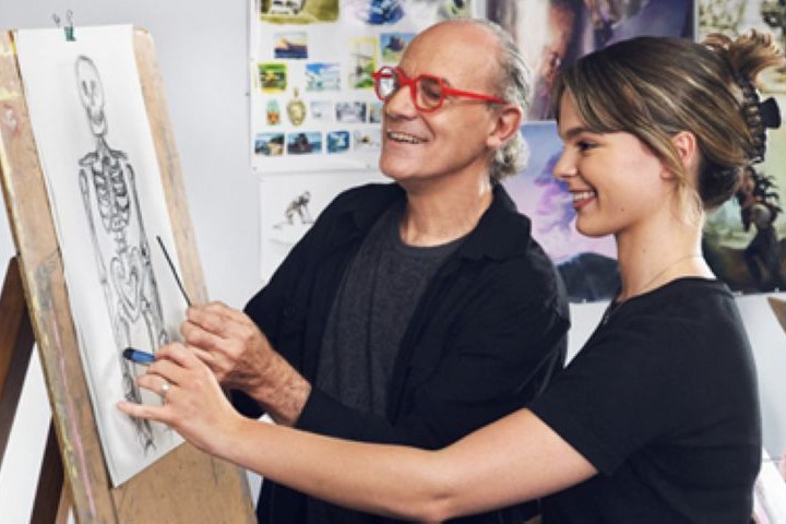 Two people working on a skeleton drawing